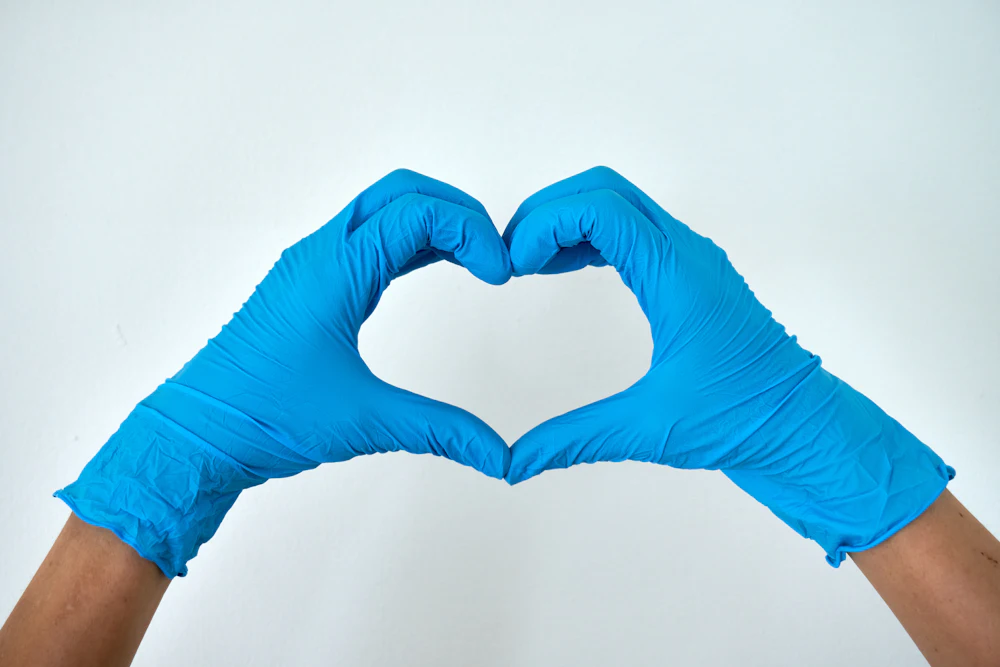 Cleaner in gloves making a heart shape